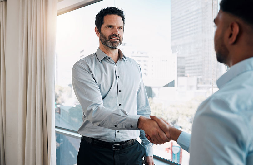 Two persons shake hands together